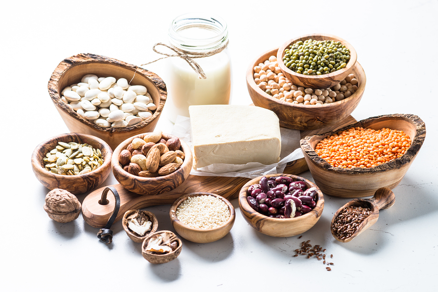 Vegan protein source. Tofu, vegan milk, beans, lentils, nuts and seeds on white table. Healthy vegetarian food.